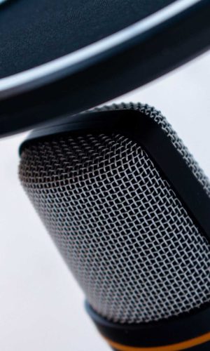 A closeup of a black and grey microphone captured on a white background